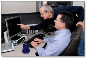 Two engineers working together at a computer